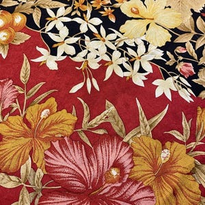May include: A colourful floral design with large hibiscus flowers in red, pink, and yellow against a red and black backdrop. The pattern includes smaller white flowers and orange fruit, creating a tropical theme.