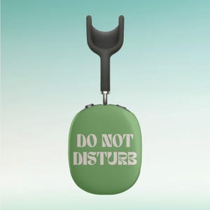 Könnte beinhalten: Grüne Kopfhörer mit einem schwarzen Kopfbügel und dem Text "NICHT STÖREN" auf den Ohrmuscheln.