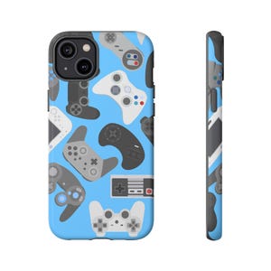 May include: A phone case with a light blue background featuring a pattern of various video game controllers in shades of grey, white, and black. The case has a black camera cutout and a matching side design.