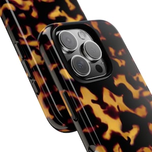 May include: A black and brown tortoiseshell phone case with a raised camera bump and three lenses.