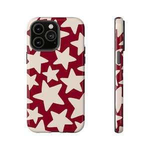 Puede incluir: Funda de teléfono inteligente con un patrón repetido de estrellas blanquecinas sobre un fondo rojo oscuro. La funda tiene un acabado brillante y un diseño protector, con una vista lateral que muestra el grosor y los botones.