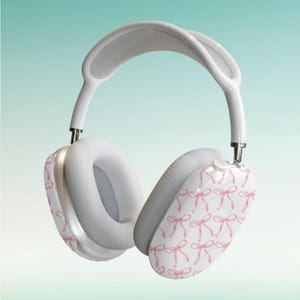 Puede incluir: Auriculares blancos de diadema con un patrón de lazos rosas en las almohadillas.
