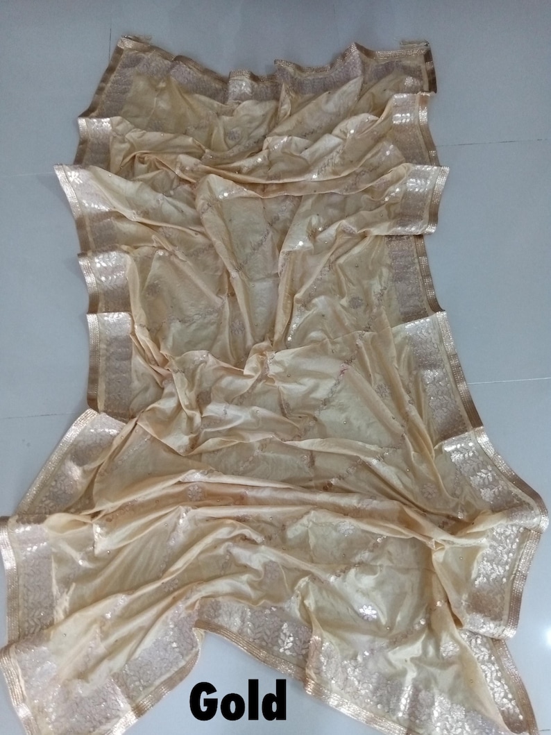 May include: A gold sequined sheer fabric with a gold border. The fabric is folded and draped on a white surface. The word "Gold" is written in black letters at the bottom of the image.