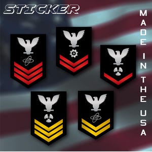 May include: A collection of black stickers featuring various U.S. Navy rank insignia. Each sticker displays a silver eagle above symbols and chevrons in red or yellow. The word "STICKER" is at the top, and "MADE IN THE USA" is printed vertically on the right.