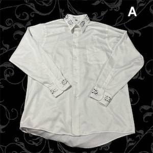May include: A long-sleeved white button-down shirt featuring a black beetle print on the collar and cuffs. The shirt includes a front button placket, a single chest pocket on the left side, and a standard collar. The letter A is visible in the corner.