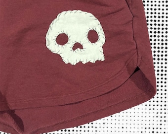Skull and bones shorts: handsydda lapptäcksbyxor i vinröd