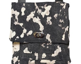 Bolsa artesanal em preto e branco com efeito tie-dye, bolsos e alça ajustável.