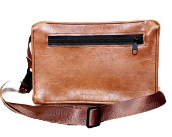 Bolsa transversal média artesanal em couro vegano, com alça ajustável.