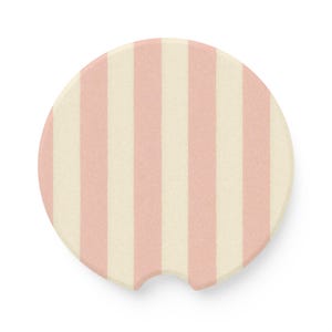 May include: A pink and white striped round coaster with a cut-out for a cup.