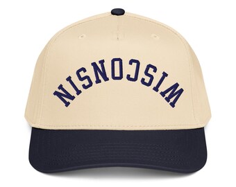 May include: A baseball cap with a cream-colored crown and a navy blue brim. The word "WISCONSIN" is arched across the front in navy blue lettering. The cap has a black button on top.