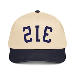 Pode incluir: Boné de beisebol com coroa creme e aba azul marinho. O boné apresenta o número "312" em letras de bloco azul marinho na frente.