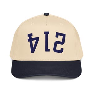 Pode incluir: Boné de beisebol com coroa creme e aba azul marinho. O boné apresenta o número "412" em letras de bloco azul marinho na frente.