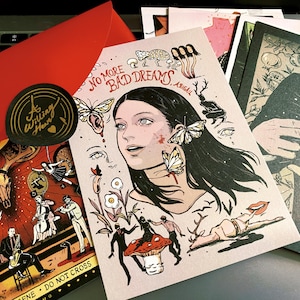 Peut inclure: Plusieurs impressions d'art et une enveloppe rouge. Les impressions présentent des illustrations aux thèmes surréalistes et fantaisistes, dont un portrait avec des papillons et le texte "NO MORE BAD DREAMS". Un autocollant noir et or avec le texte "A Willing Heart" est également visible.