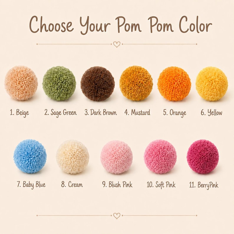 May include: A color chart titled Choose Your Pom Pom Color displaying eleven yarn pom poms in various shades: 1. Beige, 2. Sage Green, 3. Dark Brown, 4. Mustard, 5. Orange, 6. Yellow, 7. Baby Blue, 8. Cream, 9. Blush Pink, 10. Soft Pink, 11. Berry Pink.