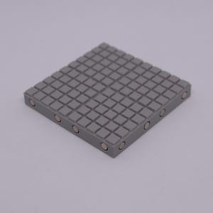 May include: A grey square-shaped magnetic mat with a grid pattern and small round magnets on the edges.