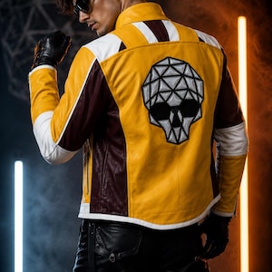 May include: A yellow, white, and dark red leather jacket featuring a large geometric skull graphic on the back. The jacket has a high collar, long sleeves with white panels, and a structured fit. Black leather gloves are worn on both hands.