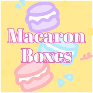 May include: A yellow background with the words "Macaron Boxes" in pink and white. Three cartoon macarons in pastel colors are scattered around the text. The macarons are light purple, blue, and pink with white filling.