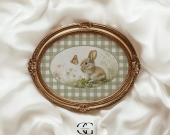 May include: A gold oval frame with a green and white checkered border surrounds a watercolor painting of a brown bunny rabbit looking at a butterfly. The painting is set against a green and white checkered background.