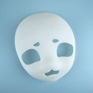May include: A white, blank mask with large eye and mouth cutouts. The mask has a smooth surface and is designed to be worn. The mask is set against a light blue background, providing a clean and simple presentation.