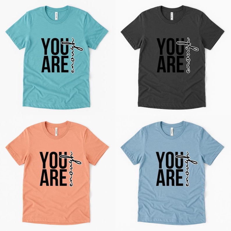 May include: Four t-shirts in different colors: teal, charcoal, peach, and light blue. Each shirt has the words "YOU ARE" in bold black letters, with "enough" written in a cursive font.