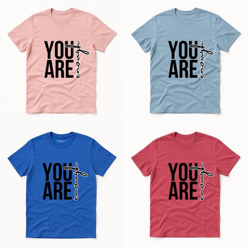 May include: Four t-shirts in pink, blue, light blue, and red. Each shirt has the words "YOU ARE" in bold black font, with "enough" written in a cursive font.