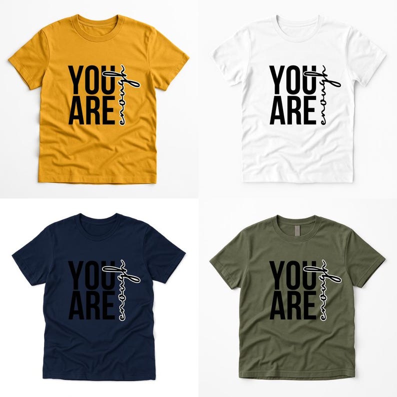 May include: Four short-sleeved t-shirts in mustard yellow, white, navy blue, and olive green. Each shirt displays the text "YOU ARE enough" in black script. The shirts are arranged on a white background.