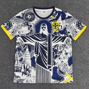 Könnte beinhalten: Weißes T-Shirt mit einem marineblauen und gelben Grafikdesign. Das Design zeigt ein Bild von Christus dem Erlöser sowie andere Illustrationen und die brasilianische Flagge. Die Ärmel haben gelbe Verzierungen.