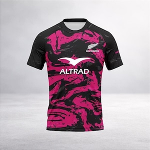 Könnte beinhalten: Schwarzes und pinkfarbenes Rugby-Trikot mit dem Text "ALTRAD" und "ALL BLACKS". Das Trikot hat einen Rundhalsausschnitt und kurze Ärmel. Das Design zeigt ein pinkfarbenes abstraktes Muster auf schwarzem Hintergrund.
