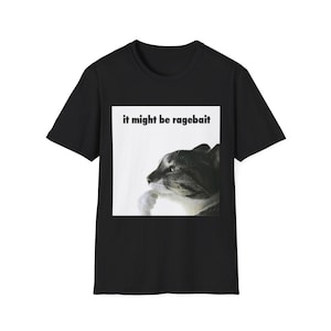May include: Black t-shirt featuring a meme with a cat and the text "it might be ragebait". The cat is depicted in black and white, with its paw under its chin, in a thinking pose. The text is in a simple sans-serif font.