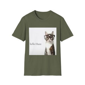 Op de afbeelding: Olijfgroen t-shirt met een afbeelding van een kat met een bril. De kat staat voor een witte achtergrond. De tekst "hello Huzz" staat links van de kat.