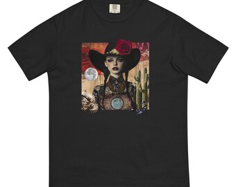 May include: Black t-shirt with a graphic of a woman wearing a red and black cowboy hat with a red rose on it. The woman is looking at the camera and has dark hair and eyes. The background is a desert scene with a cactus and a moon.