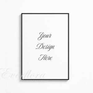 以下が含まれることがあります： 中央に黒い筆記体で「Your Design Here」と書かれた白い背景を持つ、縦長の黒い長方形のフォトフレーム。フレームは細いプロファイルで、アートワークやプリントを家庭環境で飾るのに適したすっきりとした外観をしています。