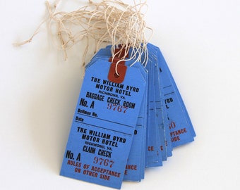 May include: A stack of blue luggage claim tags with brown leather straps and white string. The tags are from The William Byrd Motor Hotel in Richmond, VA. The text on the tags reads "Baggage Check Room" and "Claim Check" with the number "9767".