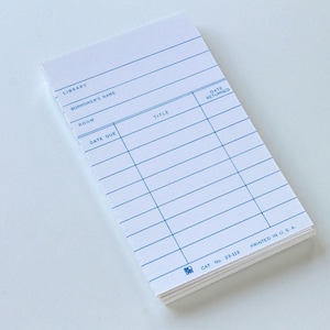 May include: A stack of white library cards with blue lines and text. The cards have spaces for "Library", "Borrower's Name", "Room", "Date Due", "Title", and "Date Returned". The bottom of the stack reads "Cat No. 23-112" and "Printed in U.S.A."