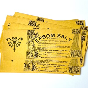 May include: A stack of yellow paper packets with black text and illustrations. The text reads "Epsom Salt" and includes directions for use, a caution, and the company name "Chemical Industrial Company".