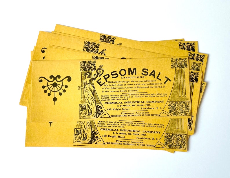 May include: A stack of yellow paper packets with black text and illustrations. The text reads "Epsom Salt" and includes directions for use, a caution, and the company name "Chemical Industrial Company".