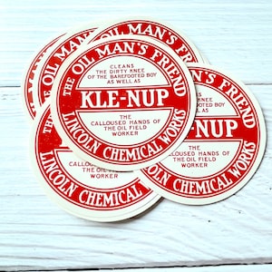 以下が含まれることがあります： 「The Oil Man's Friend Kle-Nup The Lincoln Chemical Works」と印刷された、赤と白の丸いラベル4つのクローズアップ。
