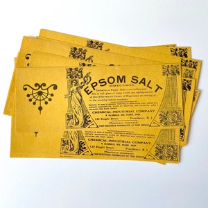 May include: A stack of yellow paper packets with black text and illustrations. The text reads "Epsom Salt" and "Chemical Industrial Company".