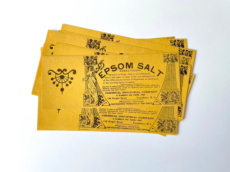 May include: A stack of yellow paper packets with black text and illustrations. The text reads "Epsom Salt" and "Chemical Industrial Company".