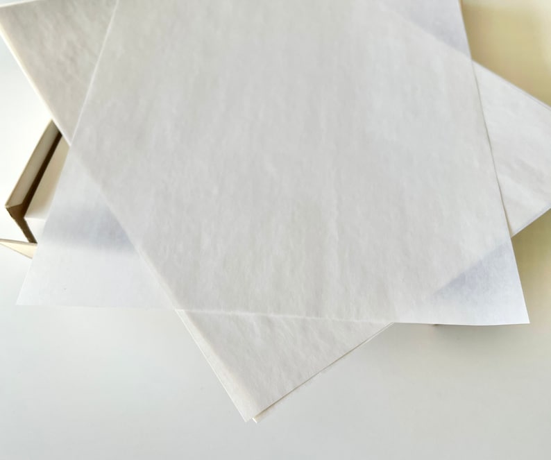 Może przedstawiać: Dwa białe arkusze papieru do pakowania złożone w kształt tr&oacute;jkąta.