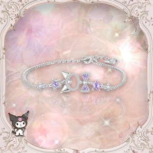 May include: A silver bracelet with a purple bow charm and star charms. The bracelet is on a pink and white background.