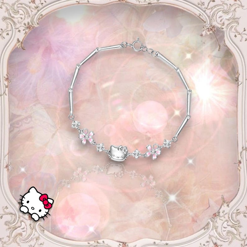 May include: A silver bracelet with a pink Hello Kitty charm and pink flower accents. The bracelet is on a pink and white background.