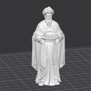 Op de afbeelding: Een wit beeldje van een geklede figuur met tulband en baard, die een kleine doos vasthoudt. De figuur is gedetailleerd met sierlijke patronen op de jurk en hoofdbedekking. Het beeld staat op een raster.