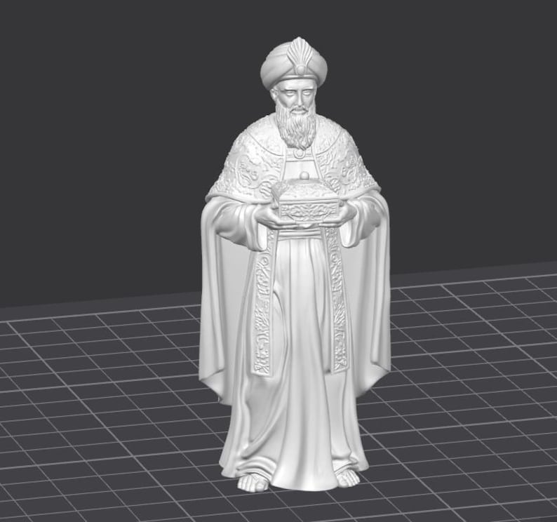 Op de afbeelding: Een wit beeldje van een geklede figuur met tulband en baard, die een kleine doos vasthoudt. De figuur is gedetailleerd met sierlijke patronen op de jurk en hoofdbedekking. Het beeld staat op een raster.