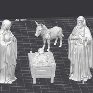 Op de afbeelding: Een 3D-geproduceerde kerststal met figuren van Maria, Jozef, het kindje Jezus in een kribbe en een ezel. De figuren zijn allemaal wit en in een klassieke pose. De sc&egrave;ne staat op een raster.