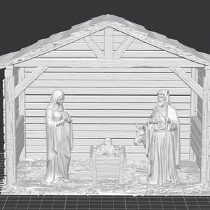 Op de afbeelding: Een witte kerststal met Maria, Jozef en het kindje Jezus in een houten stal. De figuren zijn gedetailleerd en staan voor een houten constructie met een schuin dak. De sc&egrave;ne bevat een ezel.