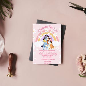 May include: Pink invitation card with a rainbow and two cartoon dogs. The text reads "Whackadoo Ellie's 2! Please join us to celebrate Ellie's 2nd Birthday Saturday, 12th March 3:00 pm to 5:00 pm 123 Somewhere St, Anywhere RSVP to Linda 123-456-7890"