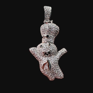 May include: A silver-toned pendant shaped like a cartoon ghost wearing a chef hat, entirely encrusted with small clear stones. The ghost features two small black circular eyes, a wide open mouth with black accents, and a small black tie detail.