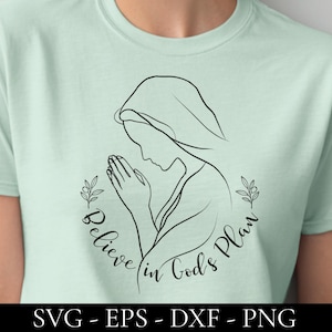Könnte beinhalten: Hellgrünes T-Shirt mit einer schwarzen Strichzeichnung einer betenden Frau, umgeben von einem floralen Kranz. Die Worte "Believe in God's Plan" sind in einer Schriftart geschrieben. Darunter steht "SVG - EPS - DXF - PNG".
