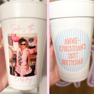 May include: Two white foam cups featuring personalized designs. The left cup displays a photograph of a child in a pink outfit with the text Sadie's 17th Birthday. The right cup features a blue and white striped circle with the text ANNE-CHRISTIAN'S 21ST BIRTHDAY.